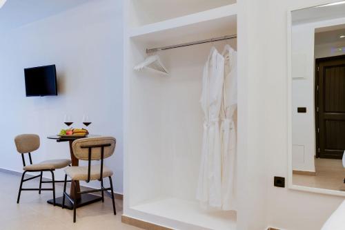 a dining room with a table and two stools at The Cosmopolitan - Karterados Urban Suites in Karterados