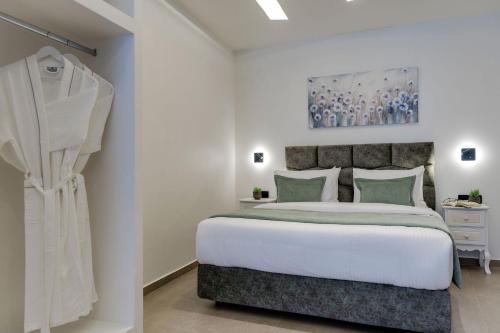 a bedroom with a large white bed with green pillows at The Cosmopolitan - Karterados Urban Suites in Karterados
