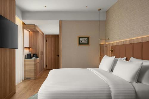 a bedroom with a large bed with white pillows at Courtyard by Marriott Prishtina in Pristina