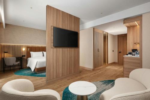 a hotel room with a television and a bed at Courtyard by Marriott Prishtina in Pristina
