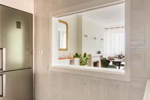a mirror on the wall of a kitchen with a refrigerator at 3BR Apt w Balcony and Sea View in Cascais