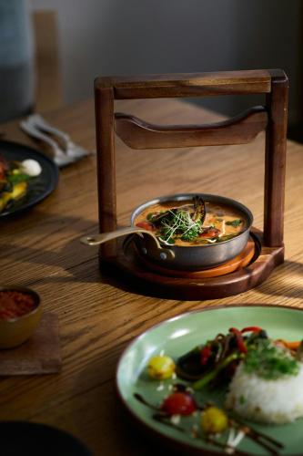a table with a bowl of soup and a plate of food at Waves Resort & Spa, Barbados, An Autograph Collection All-Inclusive Resort in Saint James