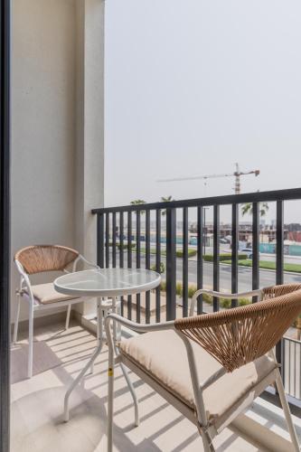 a table and chairs on a balcony with a view at Nasma - RAK Bliss 2BR Villa, Maid Room & Backyard in Ras al Khaimah