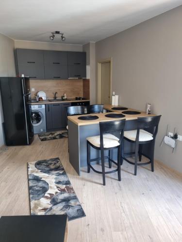 a kitchen with a table and chairs in a room at Apartament Rumqncev in Velingrad
