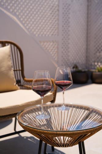 two glasses of wine sitting on a table at The Cosmopolitan - Karterados Urban Suites in Karterados