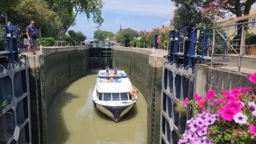 a boat in a canal with people on it at Le N 9 in Argeliers