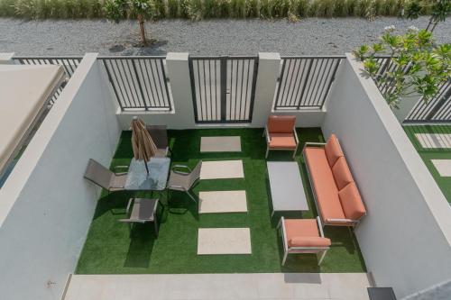 mit Blick auf einen Balkon mit Stühlen und einem Tisch in der Unterkunft Nasma - RAK Bliss 2BR Villa, Maid Room & Backyard in Ras al Khaimah