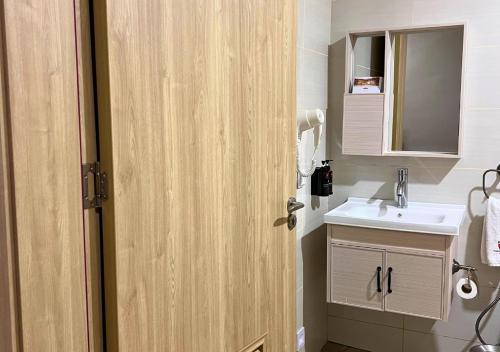 La salle de bains est pourvue d'un lavabo et d'une porte en bois. dans l'établissement Lake Naivasha Resort, à Naivasha