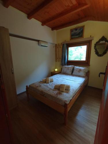 a bedroom with a bed in a room with a window at Къща за гости Аврамови in Ribarica