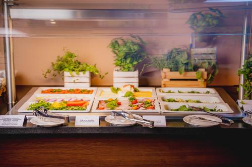 a buffet with several trays of food on display at Ambre Hotel in Rzeszów