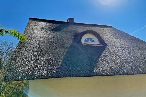 a black shingle roof with a small window on it at Ferienhaus Deich Huus in Kappeln