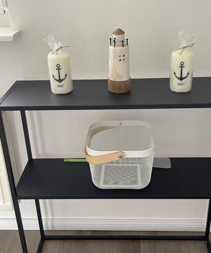 a black shelf with three containers on top of it at Ferienhaus Deich Huus in Kappeln