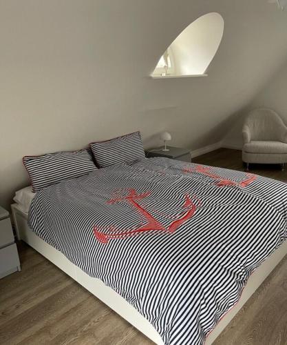 a bedroom with a bed with a black and white stripes at Ferienhaus Deich Huus in Kappeln
