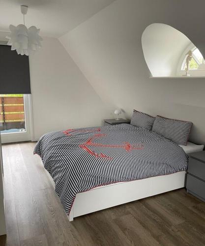 a white bedroom with a black and white bed at Ferienhaus Deich Huus in Kappeln