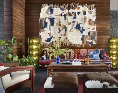 a living room with a couch and a chandelier at Graduate by Hilton Dallas in Dallas