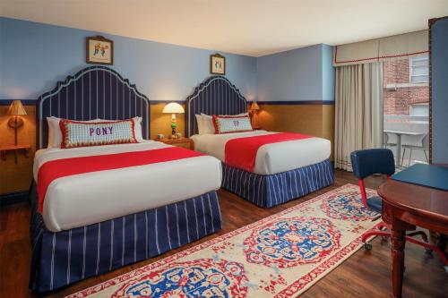 a hotel room with two beds and a desk at Graduate by Hilton Dallas in Dallas