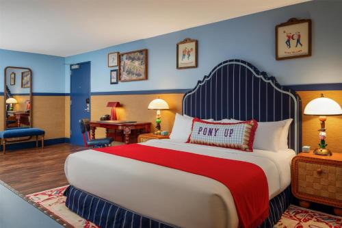 a hotel room with a large bed with a red blanket at Graduate by Hilton Dallas in Dallas