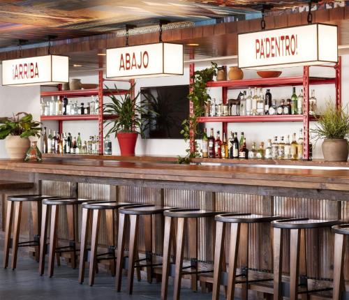 a bar with stools in front of a counter at Graduate by Hilton Dallas in Dallas