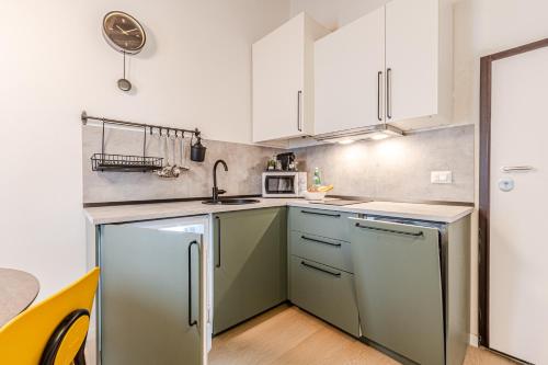 a kitchen with green appliances and white cabinets at Incanto apartment in Laiatico