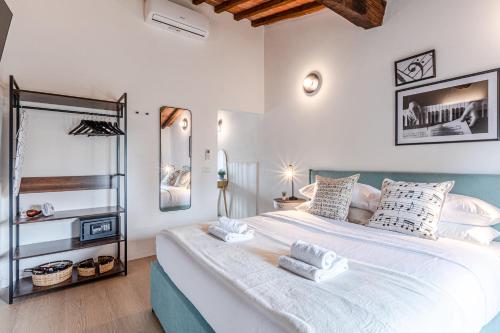a bedroom with a large white bed with towels on it at Incanto apartment in Laiatico