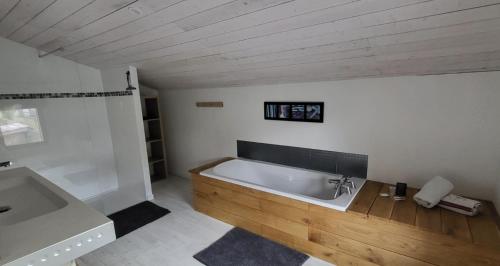 a bathroom with a bath tub and a sink at Belle maison avec piscine à 5 min de la cathédrale de Bazas in Bazas