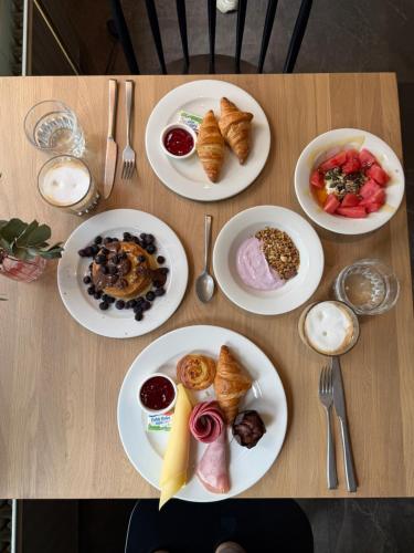 a table with plates of breakfast food on it at Het Hart van Weesp in Weesp