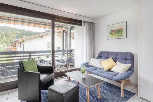 a living room with a couch and a table at Zuhause in den Alpen Ihre Ferienwohnung mit Hallenbad und Sauna in Lenzerheide