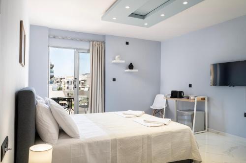 コス・タウンにあるAvra Suitesの白いベッドルーム(ベッド1台、バルコニー付)