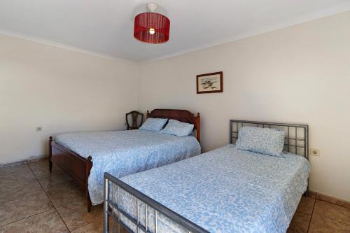 Dos camas una al lado de la otra en un dormitorio. en Quinta Natureza de Coura, en Paredes de Coura