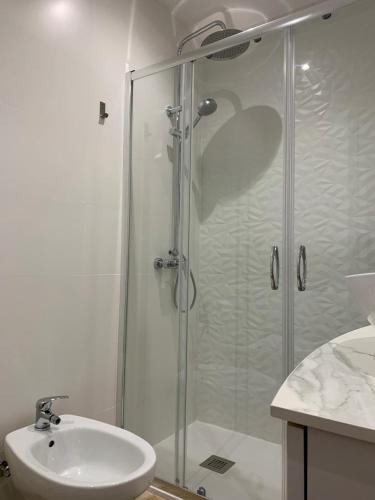 a bathroom with a shower and a sink at HabitaHost Colón in Cuenca