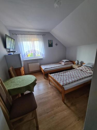 a room with two beds and a chair in it at Pokoje gościnne u Ewy Cisna in Cisna