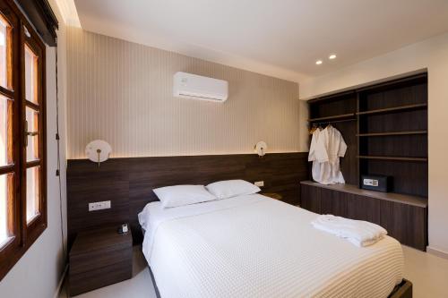 a bedroom with a large bed with white sheets at Opera House Hotel in Symi