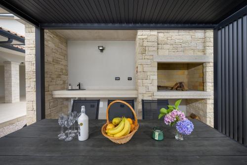 a table with a basket of bananas and wine glasses at Villa Apolonia by IstriaLux in Pazin