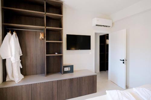 a bedroom with a closet with a flat screen tv at Opera House Hotel in Symi