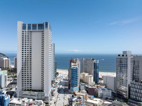 a city with tall buildings and the ocean at Marysol by Haeundae beach in Busan