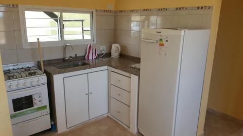 cocina con nevera blanca y fregadero en Apartamentos Los Teros en San José