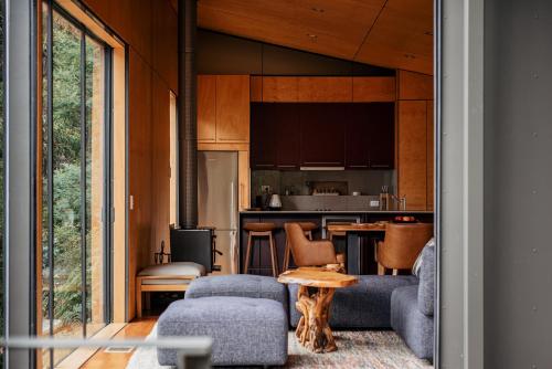 a living room with a couch and a table at Hidden on Huon in Glendevie