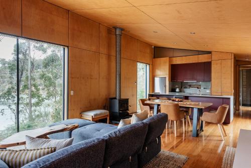 a living room with a couch and a table at Hidden on Huon in Glendevie