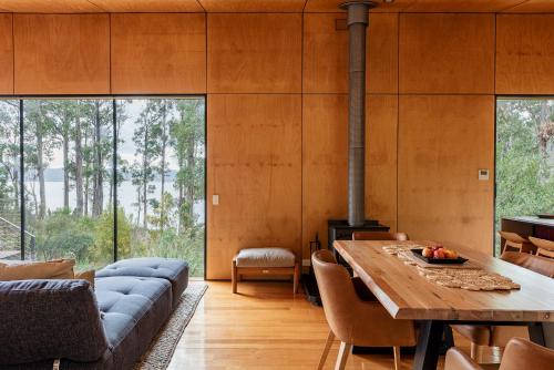a living room with a wooden table and a couch at Hidden on Huon in Glendevie