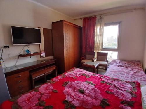 a bedroom with a bed and a desk and a television at Aqua view North coast-الكيلو 91- in El Alamein