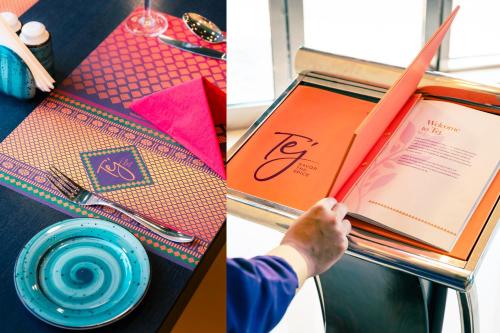 a table with a book and a person holding a plate at Ramada by Wyndham Dubai Deira in Dubai
