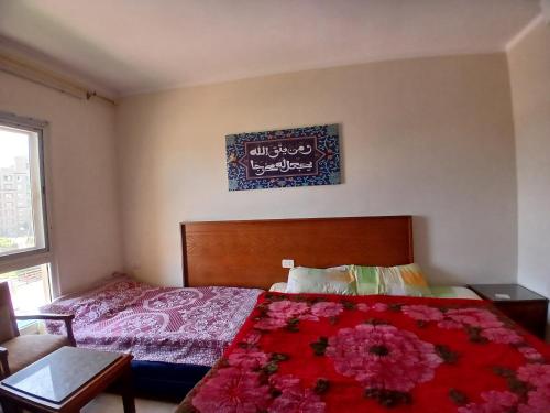 a bedroom with a bed with a red comforter at Aqua view North coast-الكيلو 91- in El Alamein