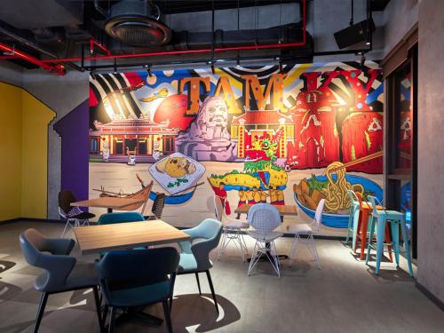 a room with tables and chairs and a mural at Tru By Hilton Tam Ky City Centre in Tam Ky