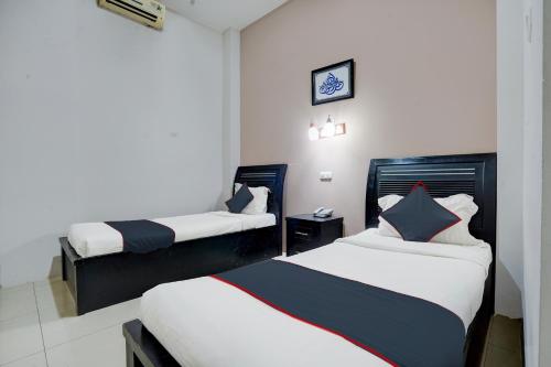 a hotel room with two beds in it at Townhouse Oak Padang near RTH Imam Bonjol formerly Bunda Hotel in Padang