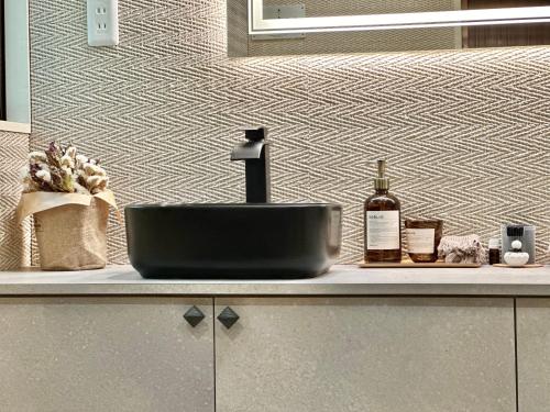 a bathroom counter with a sink and a bottle of wine at 森の街34# Nature Escape BBQ in Wada