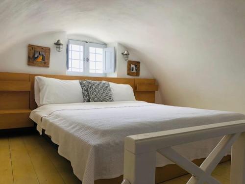 a white bed in a room with a window at Villa Artemis by ΜΡS in Pirgos