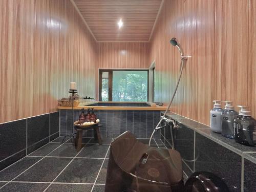 a bathroom with a tub and a table and a window at 森の街34# Nature Escape BBQ in Wada
