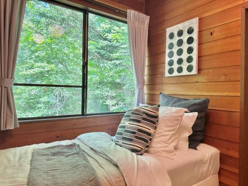 a bedroom with a bed and a window in a room at 森の街34# Nature Escape BBQ in Wada