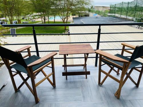 a table and two chairs and a wooden table on a balcony at Lake Elementaita Manor in Gilgil