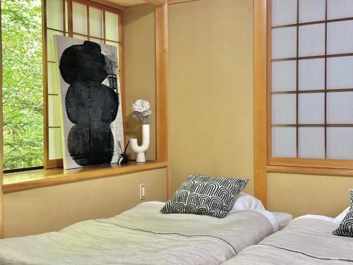 a room with two beds and a window with a statue at 森の街34# Nature Escape BBQ in Wada